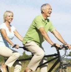 Mature couple riding tandem bike