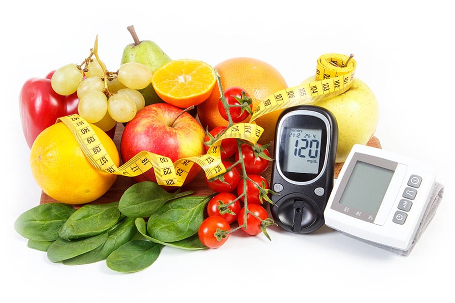 Glucometer for checking sugar level and blood pressure monitor with fruits with vegetables