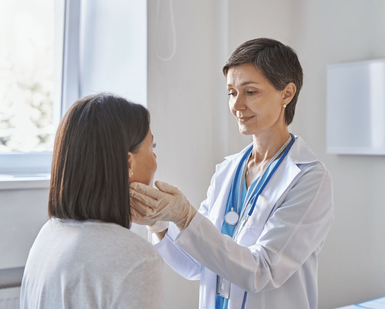 A doctor examining a woman's thyroid
